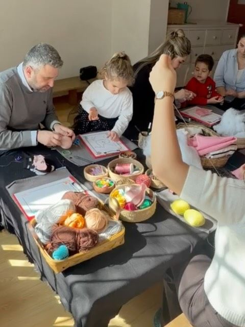 Yetişkinler ve çocukların aynı masada iplerle çalıştığı atölye